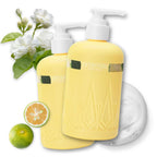 Two pale yellow pump bottles labeled onsensou Double Edge, styled with white flowers, a lime, a sliced lime, and a white circular pad on a white background.