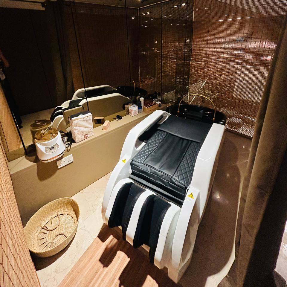 Massage chair in a modern interior setting with mirrors and decor elements.